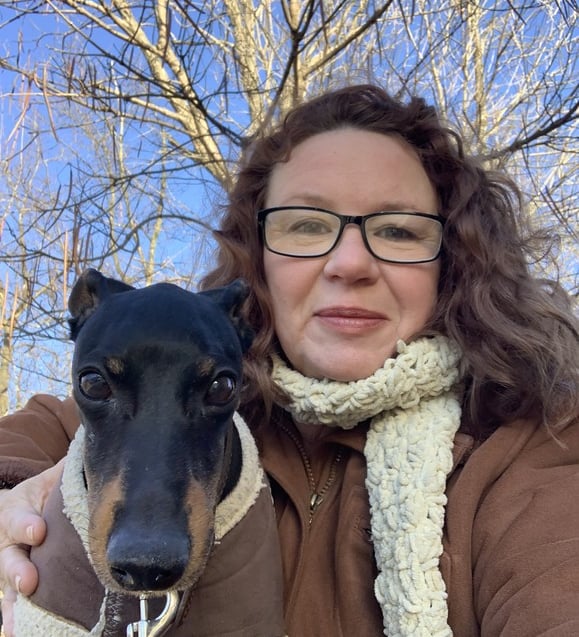 smiling woman owner in winter coat with cute dog