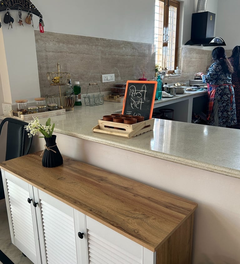 Modern white and wood sideboard in an open kitchen featuring a marble countertop and chalkboard menu.