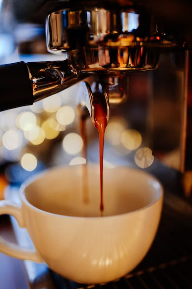 a cup of coffee being poured into a cup of coffee