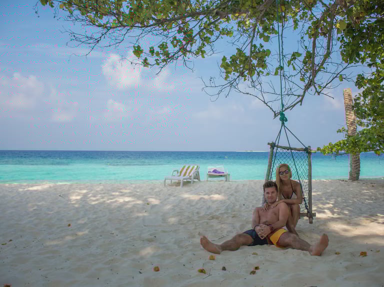 a man and a woman sitting on a beach