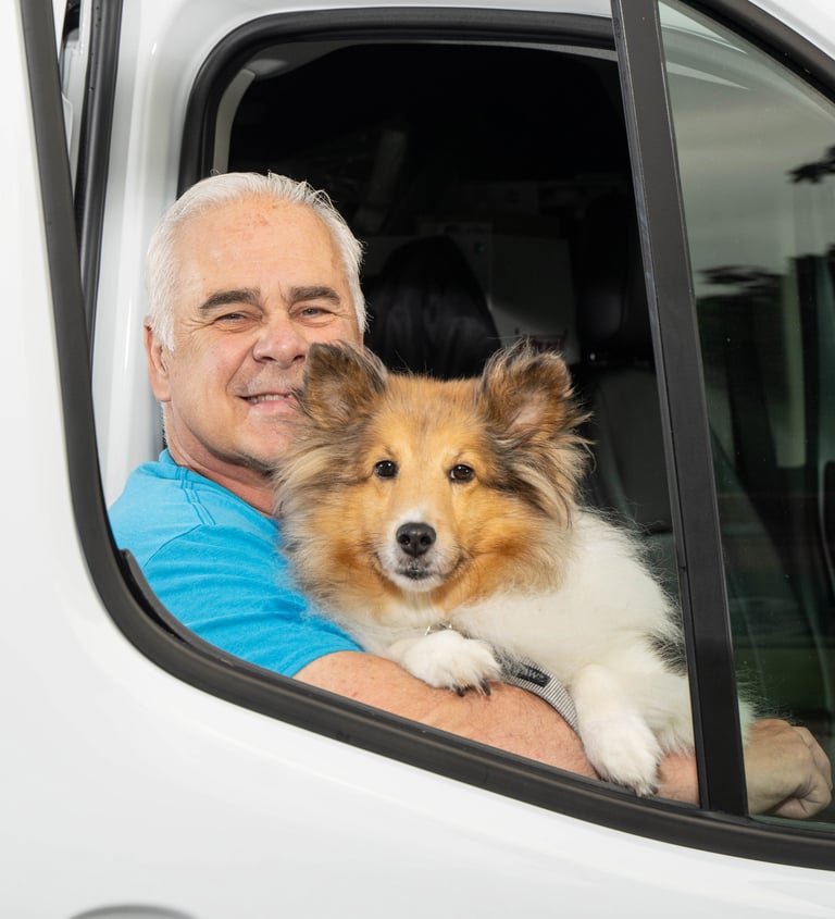 John holding his dog in the service truck