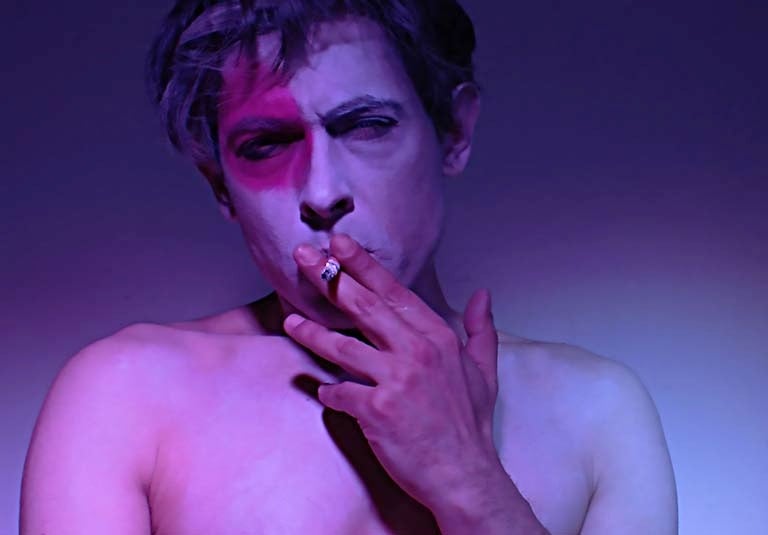 David Noir, autoportrait torse nu, oeil maquillé de rose et cigarette aux lèvres