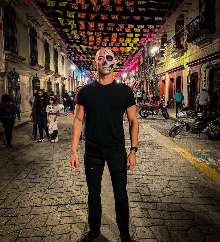 A bald man with half his face painted in Oaxaca