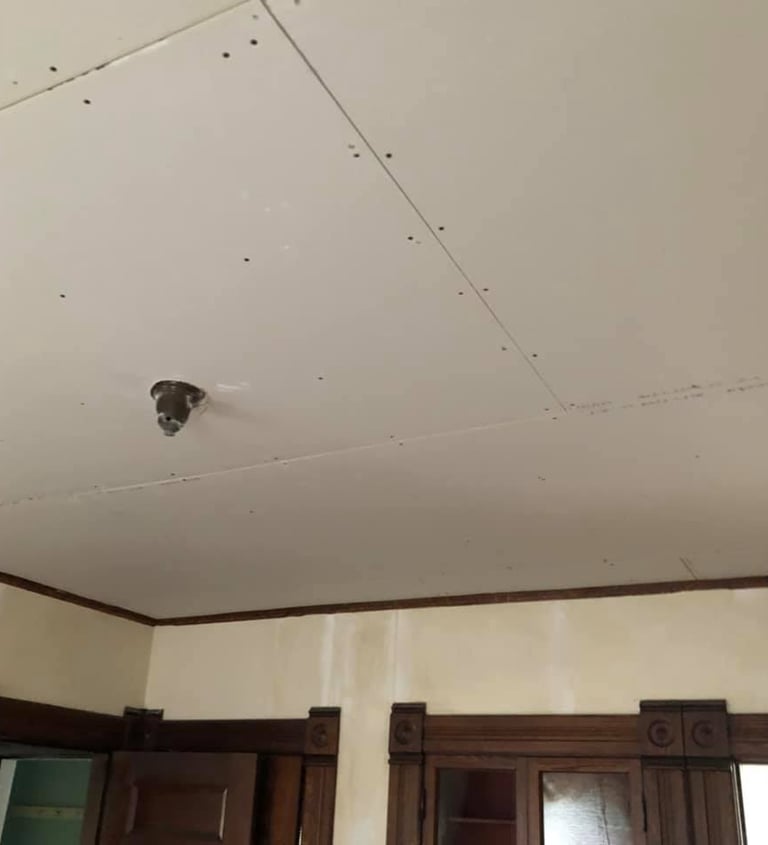 new drywall hung on ceiling of home with wood trim