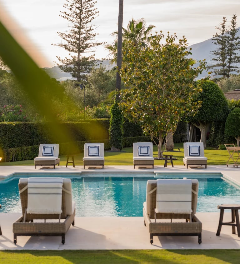Sunlit pool terrace with lined sunbeds