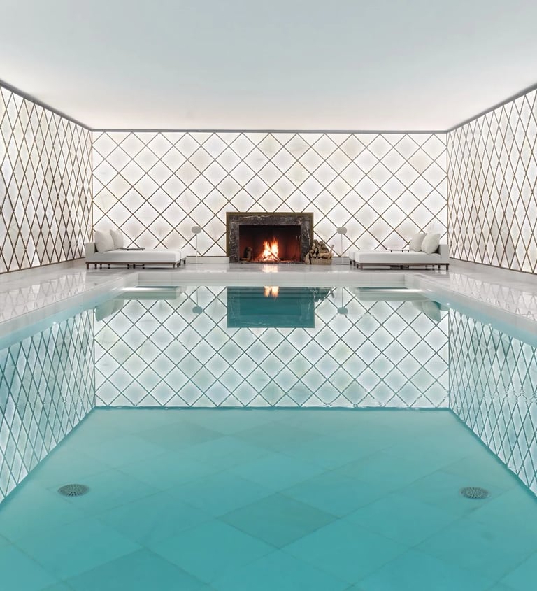Indoor spa pool with fireplace and tiled walls