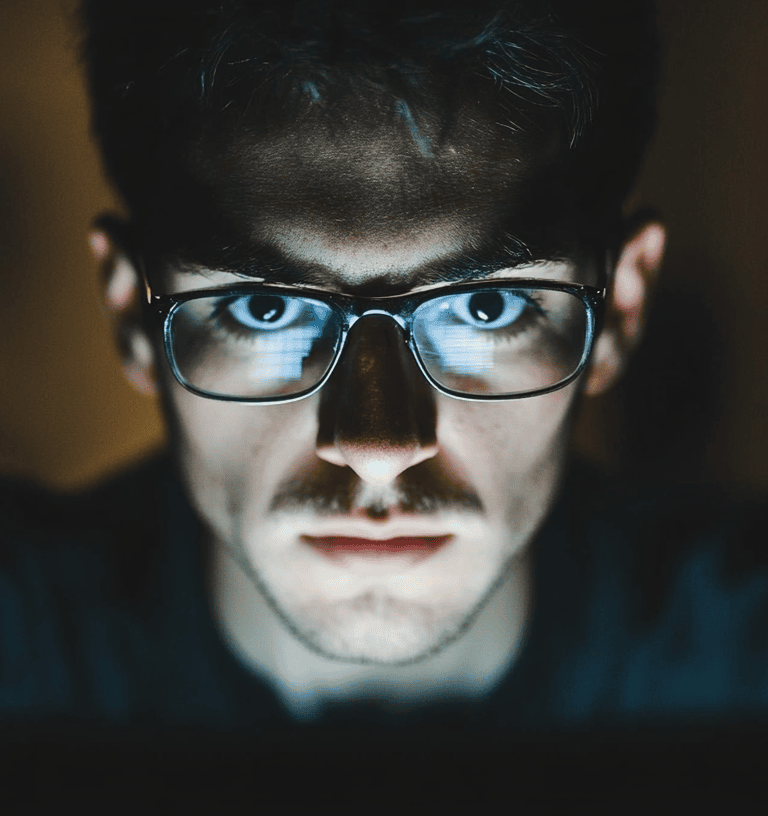 a man in glasses and glasses looking at a laptop