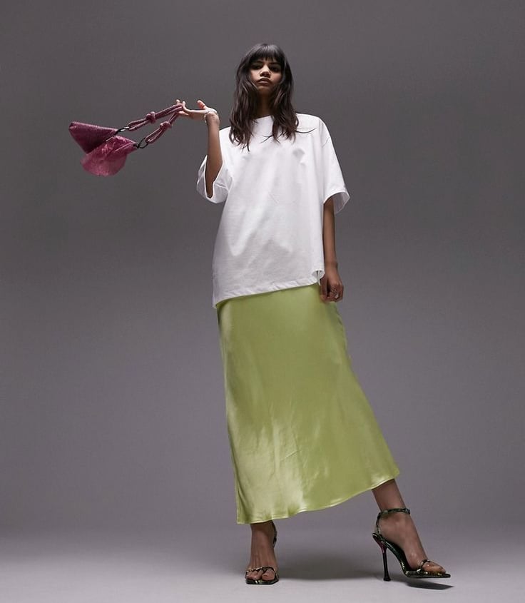 a woman in a white shirt and green skirt
