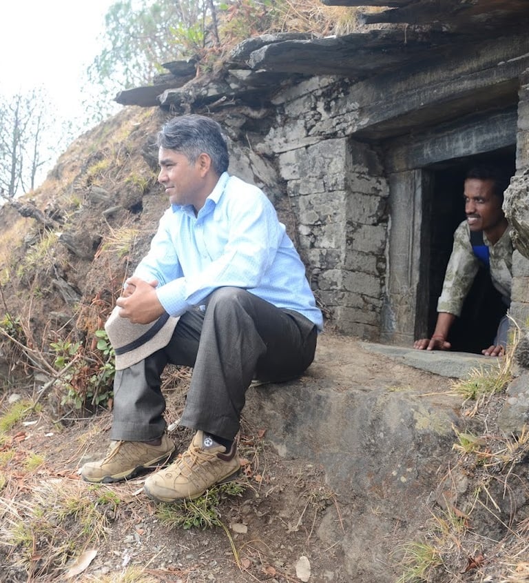 पहाड़ी एकांत में बैठे व्यक्ति का मौन चिंतन — मानसिक संतुलन और आत्मशांति का प्रतीक