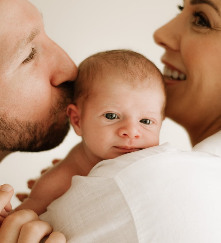 tender moment between baby and parents, part of a newborn lifestyle photography session in Adelaide