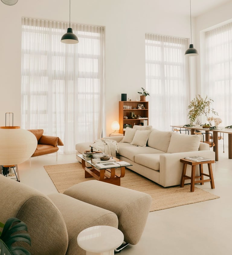 Bright and airy living room with neutral-toned furniture and large windows.