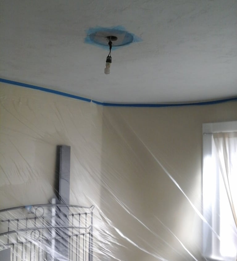 room with plastic masking on walls