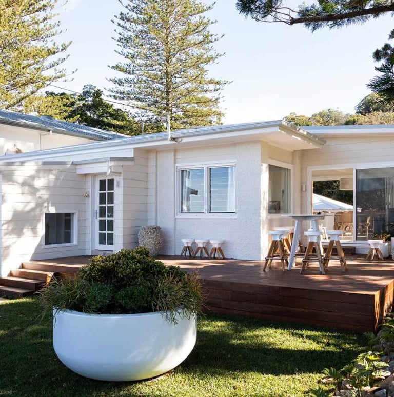 a house with a large white planter and a large white potted planter