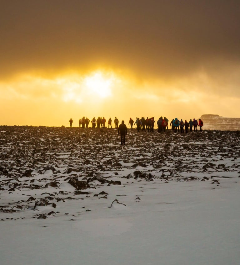 a group of people standing on a snowy field in the Faroe Islands