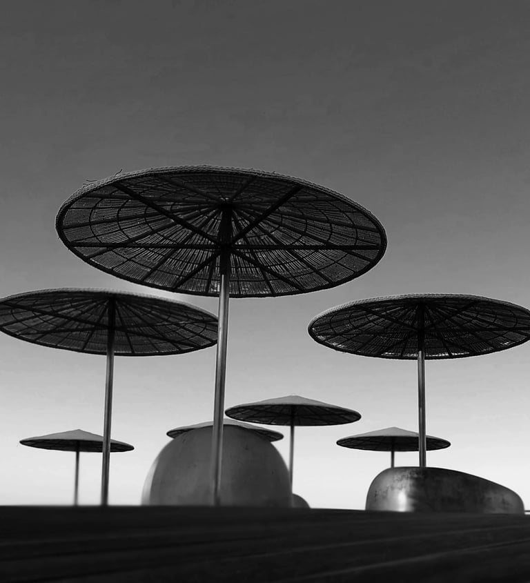 Black and white photo of umbrellas on a pier