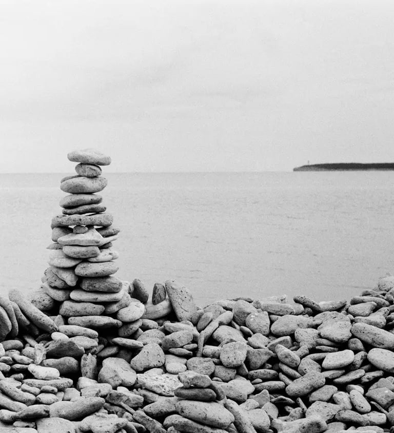 A monochrome image of a pile of stones on a stony beach