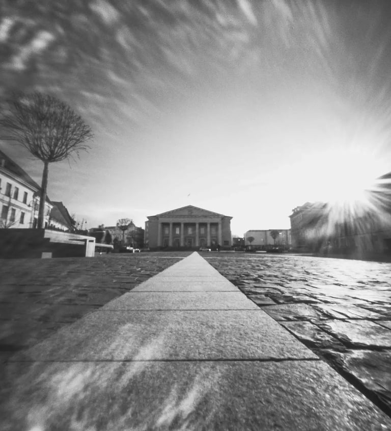 Black and white photo of a street with a distant building