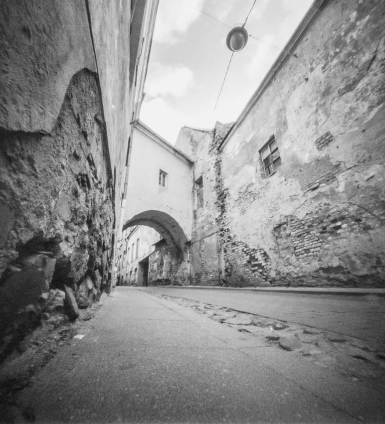 An atmospheric black and white picture showcasing a charming alleyway in Vilnius Old Town