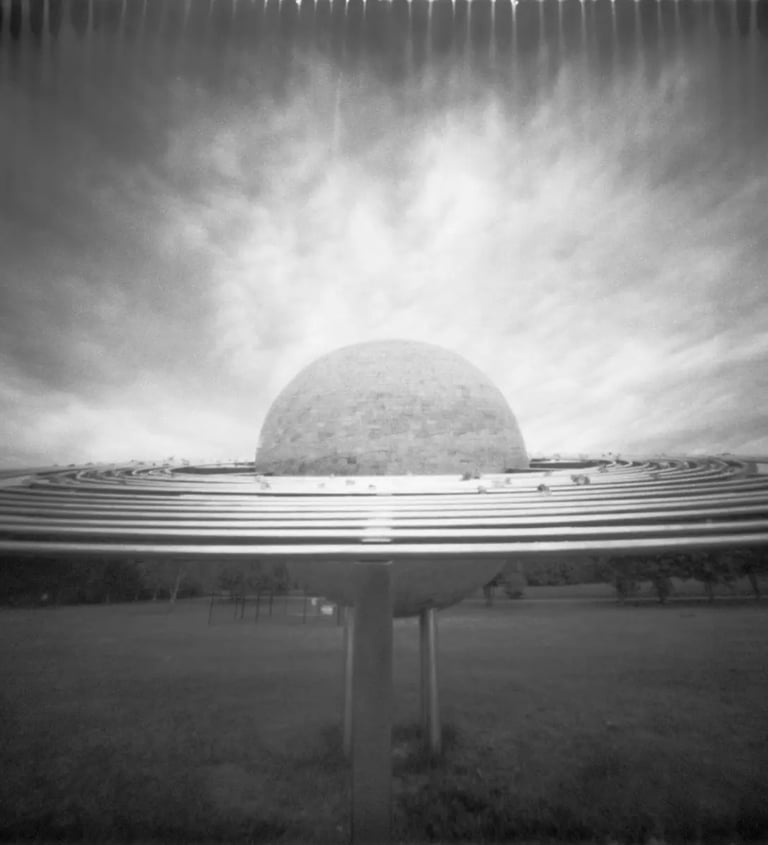 Black and white pinhole picture of a massive orb in the sky.