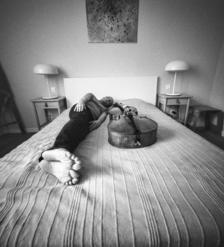 Musician relaxing on bed with cello