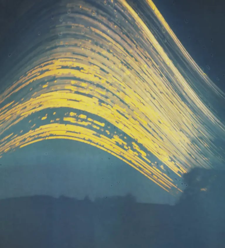 Long exposure captures wave's motion under sun path in blue