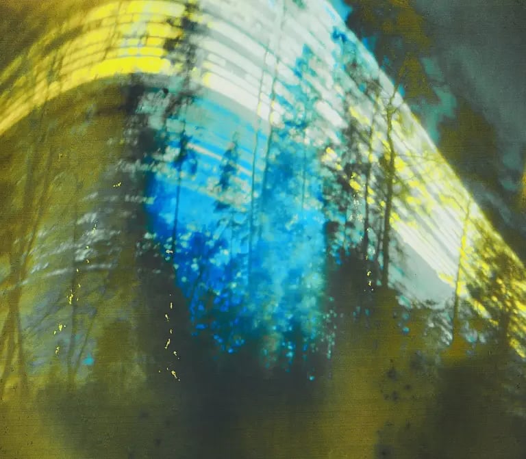 Sun path visible in blurry wood against blue sky