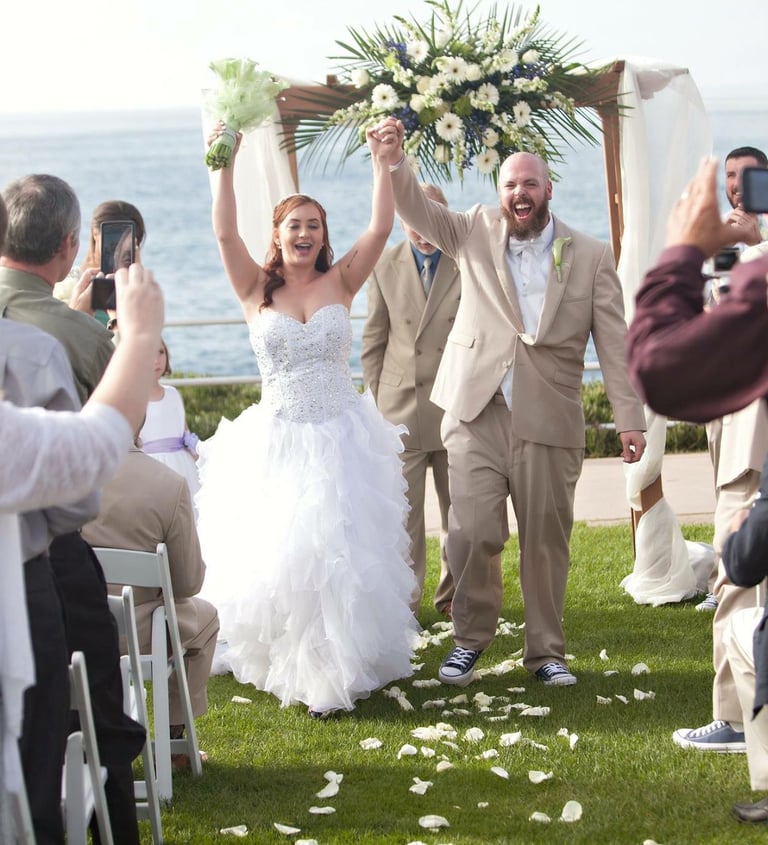 couple celebrating wedding at ellen browning scripps park, la jolla overlooking blue ocean