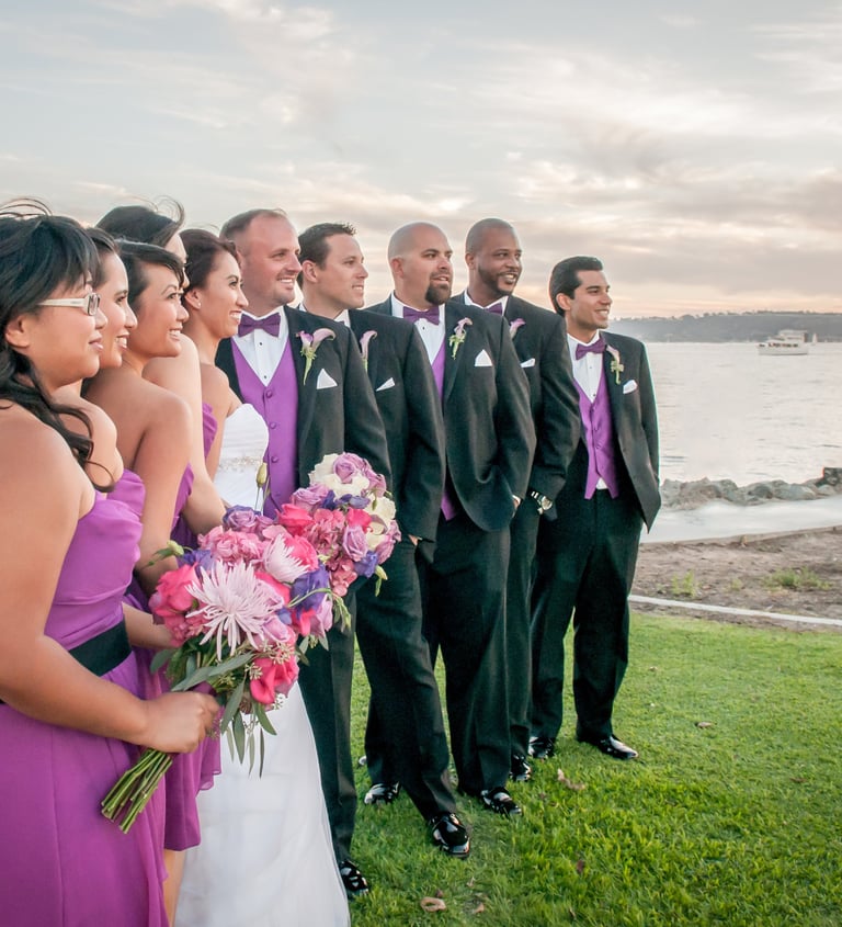 bridal party in purple with purple & pink flowers at wedding at Harbor Island park