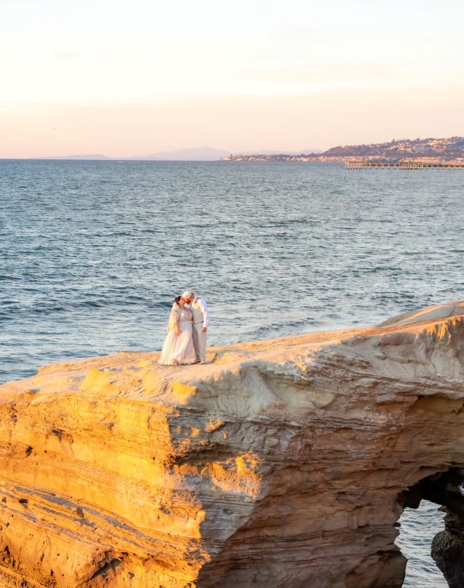 Couple kissing on cliffside bluff at Sunset Cliffs at Osprey Point