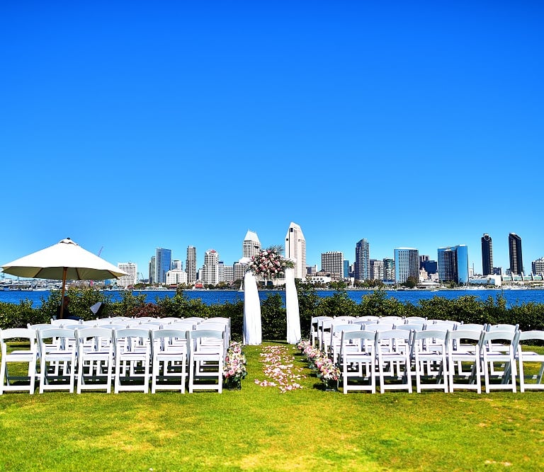WEdding ceremony set up with floral decorated arbor and pink florals at Centennial Park, Coronado
