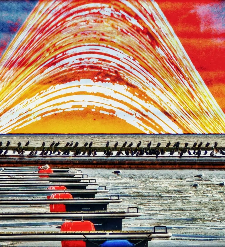 A row of boats docked in a marina, with calm water reflecting the vessels and surrounding scenery