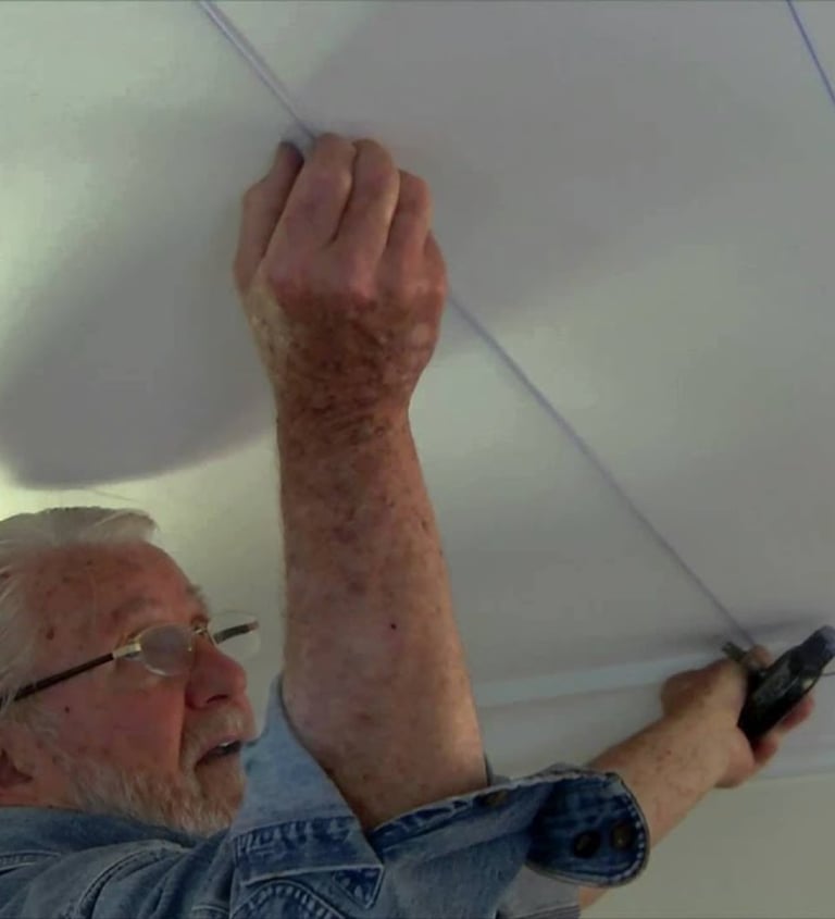 Homem instalando placas de isopor no forro