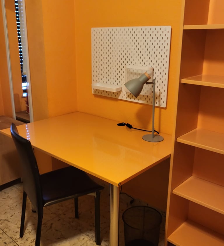Habitación con amplio escritorio y estantería