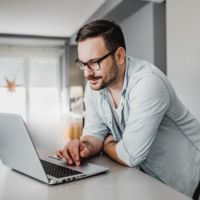 man checking payments on laptop