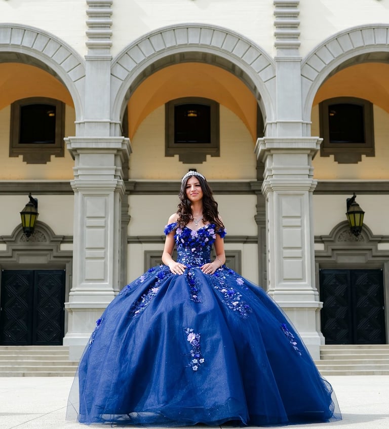 a Qunice in a blue dress sitting on a staircase