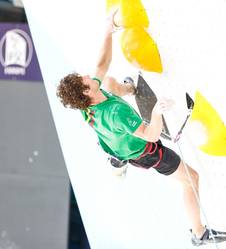 a man lead climbing in a climbing competition