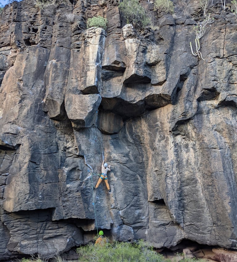 a lead person climbing on rocks
