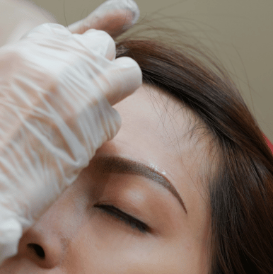 a woman getting her eyebrows done by a professional hairdresser