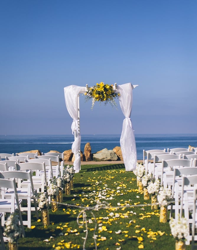 wedding set up at Calumet Park, la jolla, arbor with sheer linens and yellow flowers
