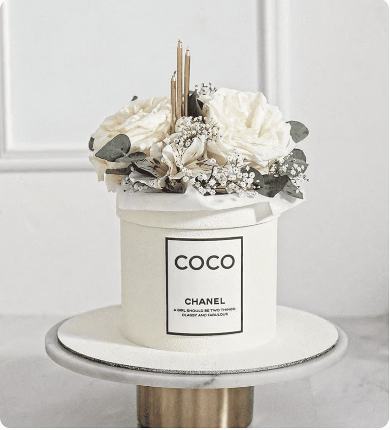 a chanel perfume bottle with flowers in a white box