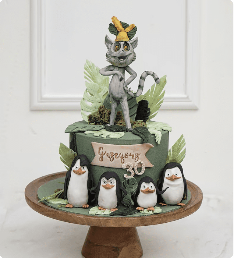 a cake with a cat and penguins on it