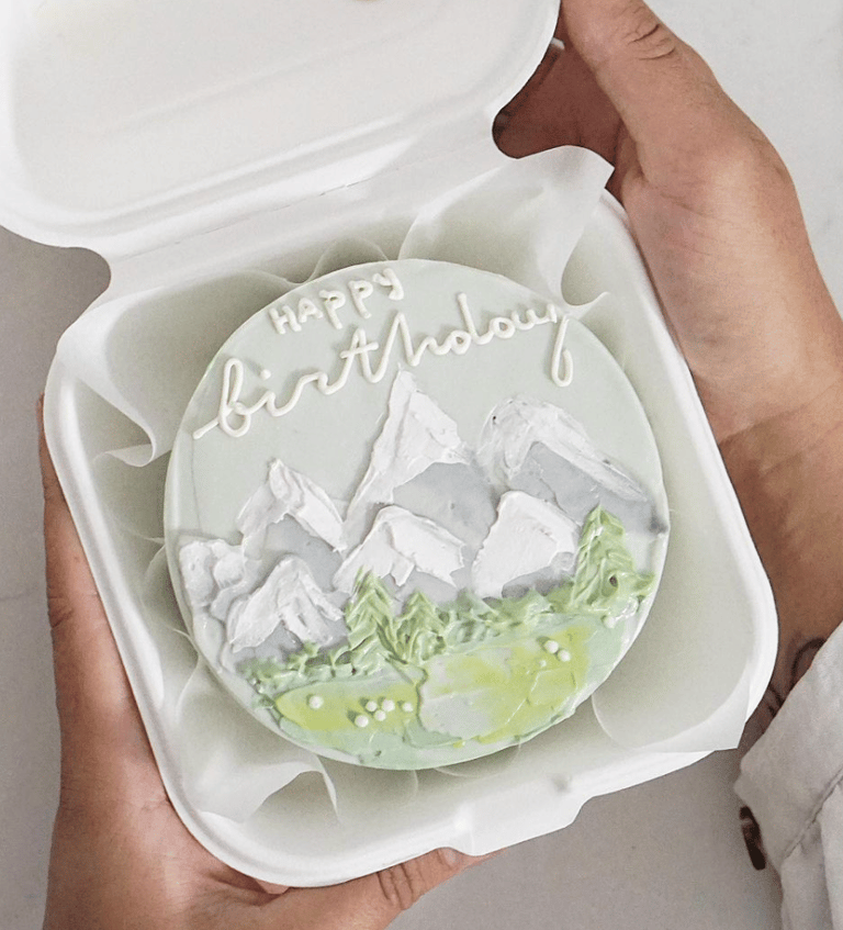 a person holding a cake with a happy birthday cake