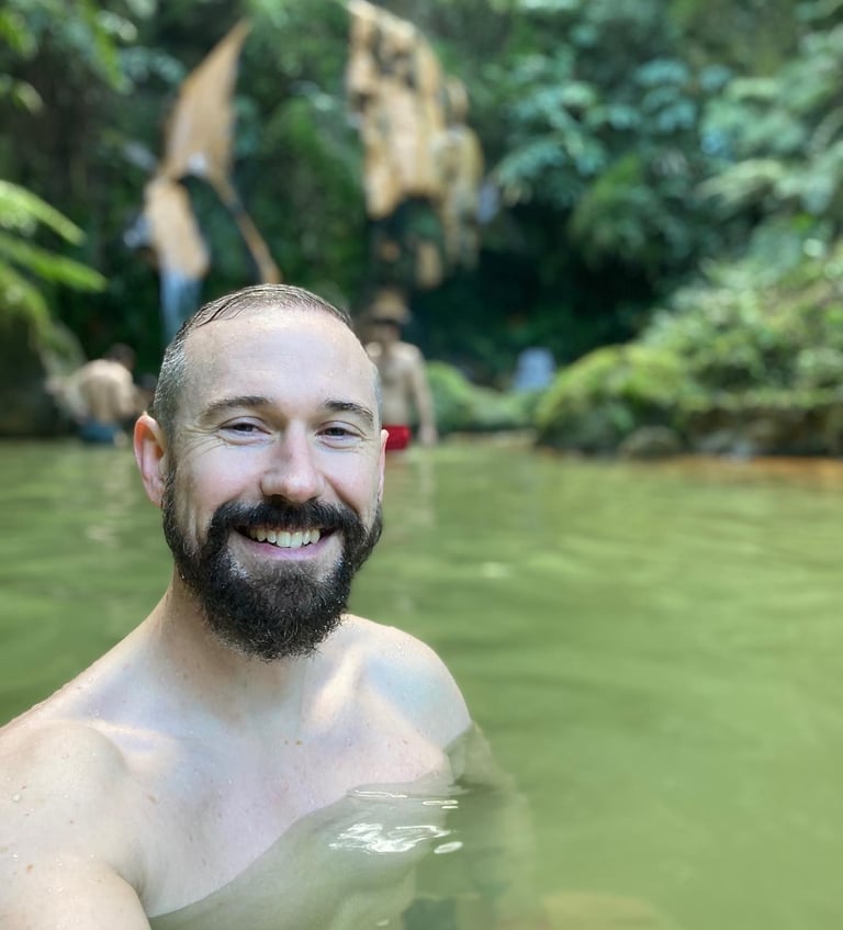 a middle aged man happy in a volcanic heated pool in azores