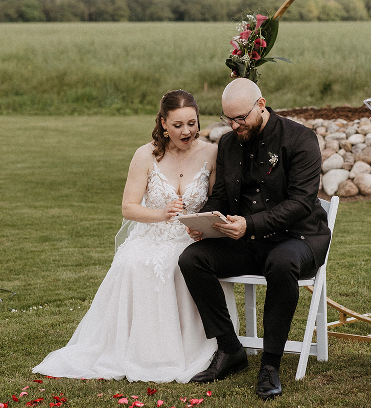 das Hochzeitspaar wird mit einem Video ihrer Lieblingsband überrascht. die beiden blicken erstaunt auf das iPad