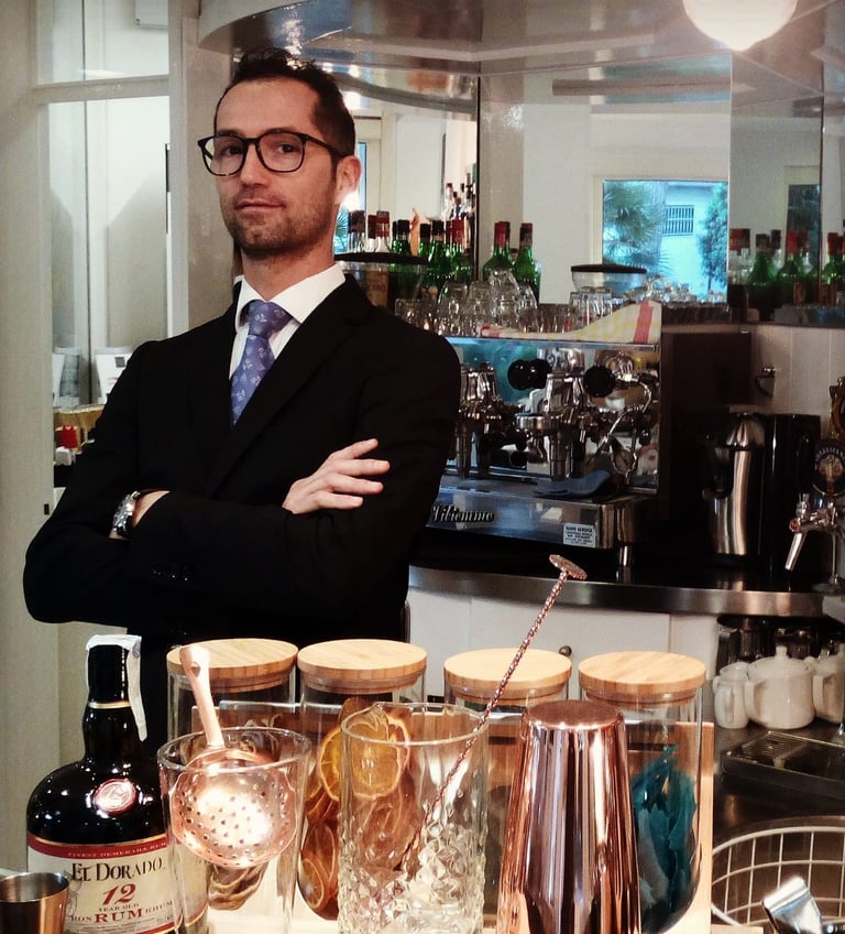 a man in a suit and tie standing in front of a bar