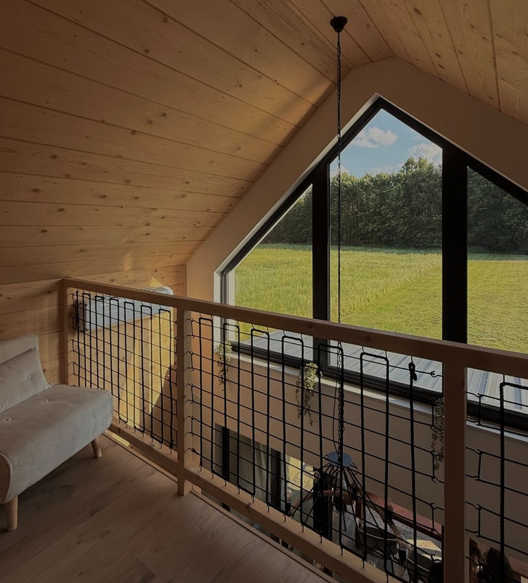 Pierwsze piętro domku (atresola) z dużym trójkątnym oknem od połowy ściany aż po dach.