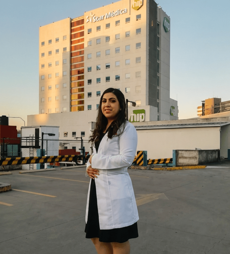 Doctora con bata blanca de pie frente al edificio del hospital Star Médica.
