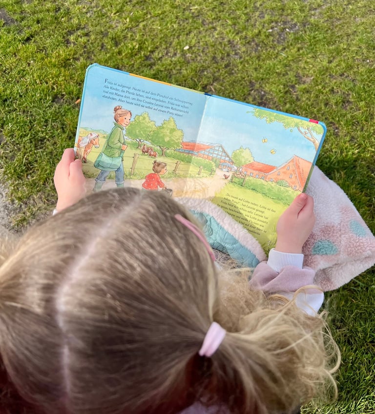 Ponytante - Kind schaut das Buch Mein erster Tag auf dem Ponyhof