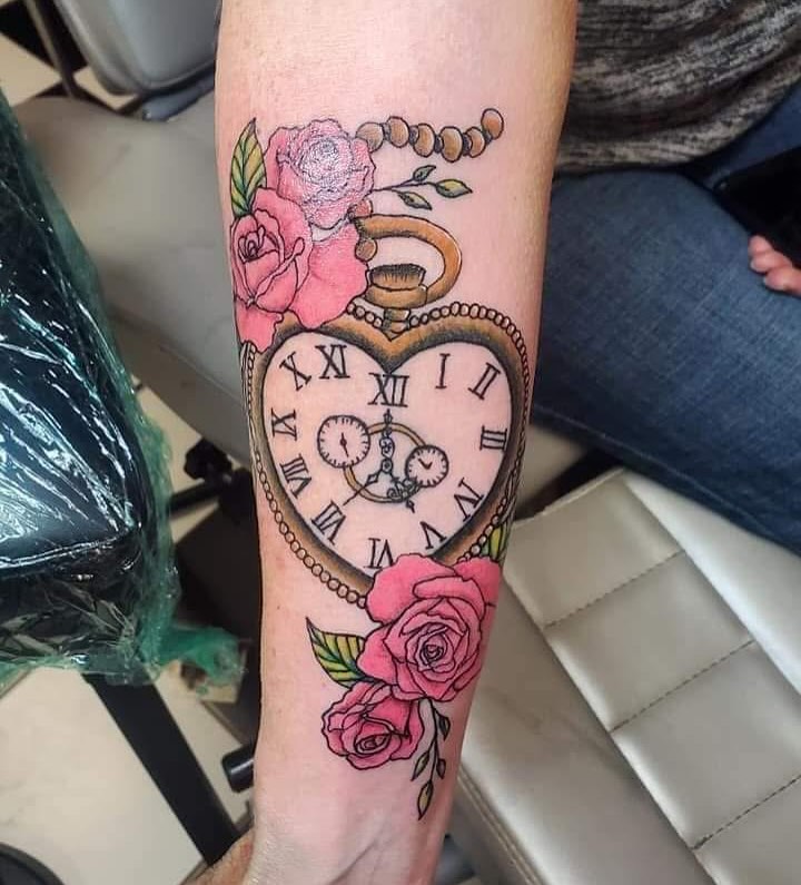 a clock on a wrist tattoo of a heart shaped clock