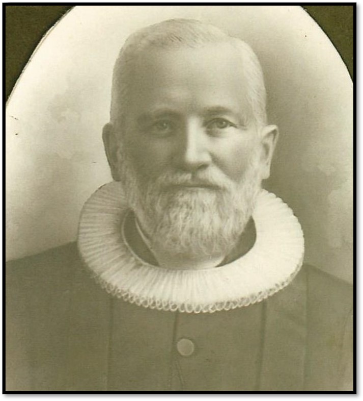 A man with a white ruffled collar and a white beard and mustache, black and white